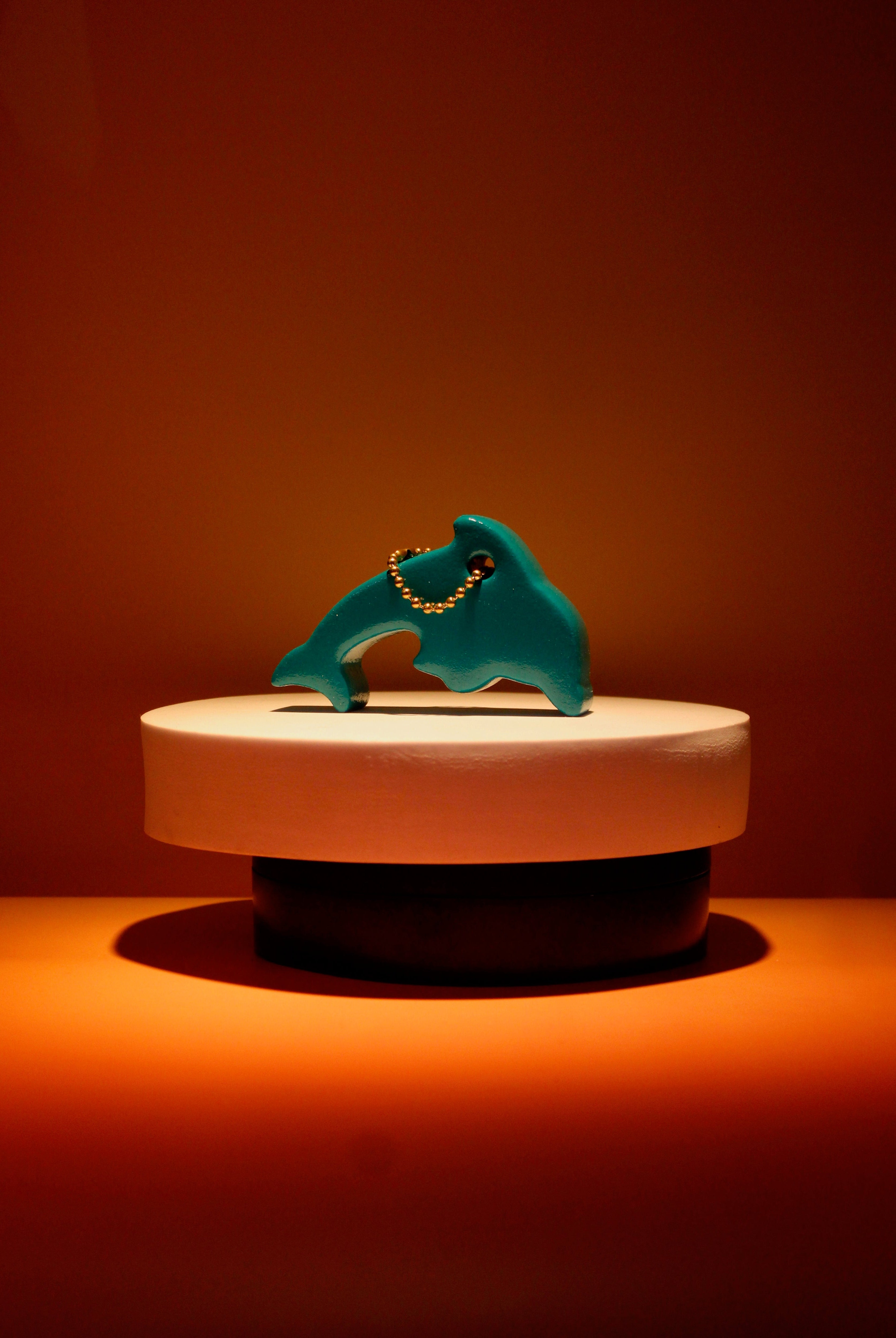 a dolphin keychain on a pedestal