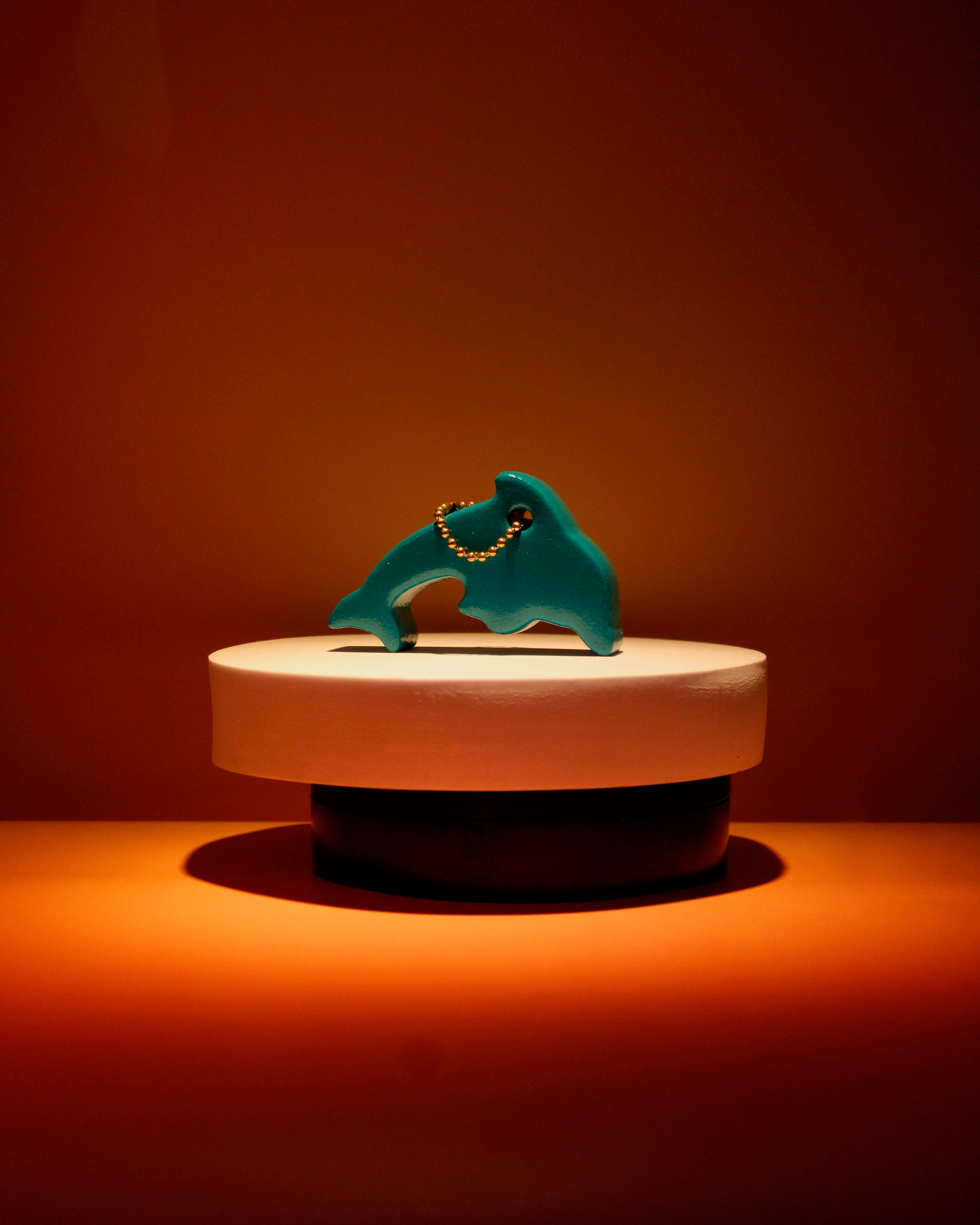 a dolphin keychain on a pedestal