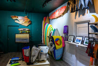 Used surfboard rack at Pemulis — consignment boards from local shapers